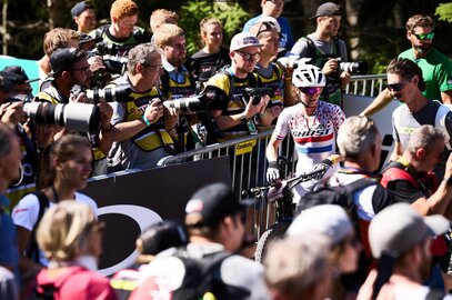 Mountainbiker fährt auf einem Waldtrail bergauf